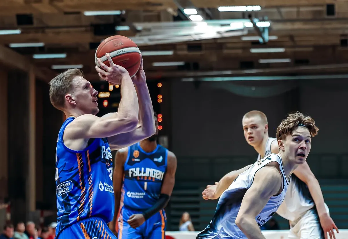 Nikolas rising into a shot with a defender closing in